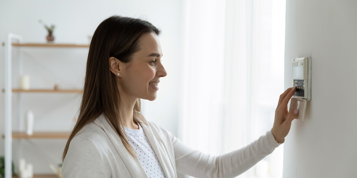Woman checking smart thermostat