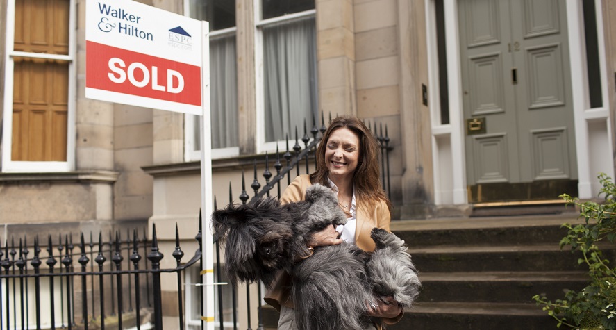 Woman with dog outside sold property